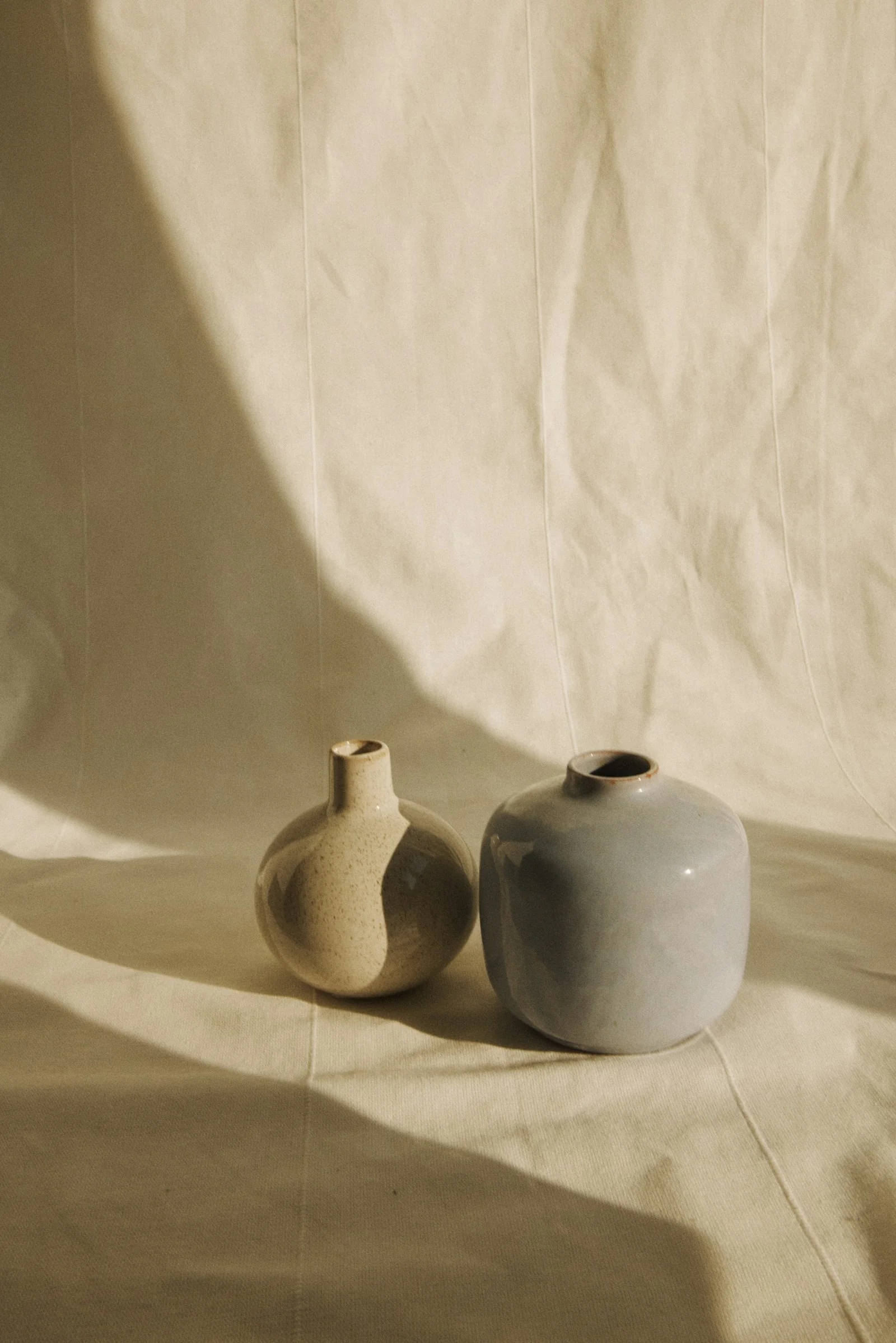 Handcrafted ceramic vessels resting on natural linen